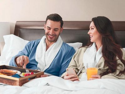 Dad and mom relax in bed in Sobel at home luxury hotel robes
