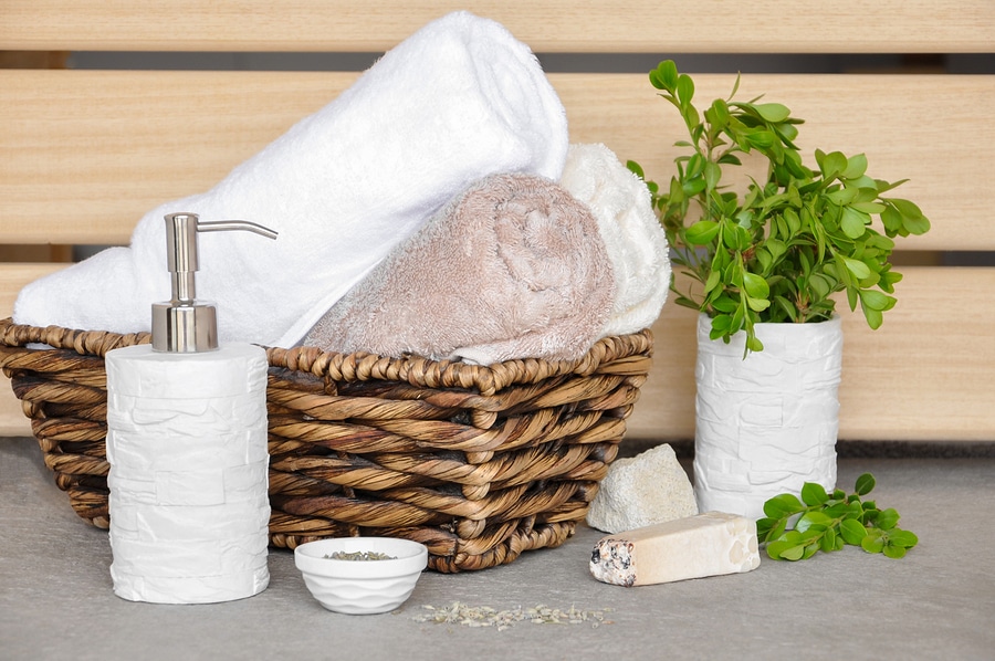 soapherbs sponge and towels in a wicker basket on a light background