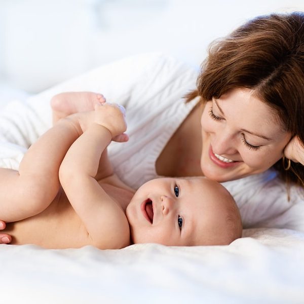 mom and baby on white bed showing quality sheets that are soft and comfortable