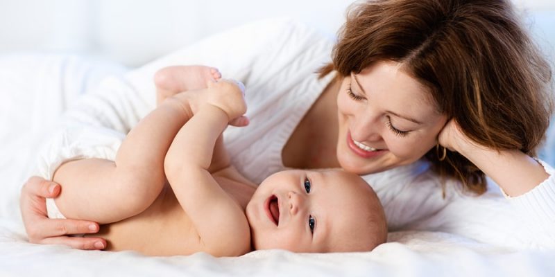 mom and baby on white bed showing quality sheets that are soft and comfortable