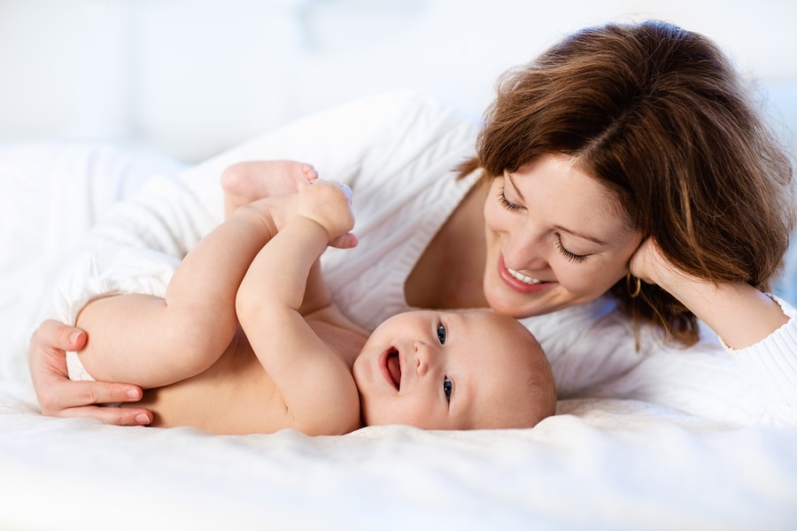 mom and baby on white bed showing quality sheets that are soft and comfortable