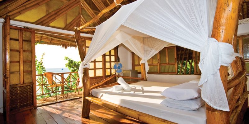 eco lodge bedroom with bamboo furniture and natural organic linens