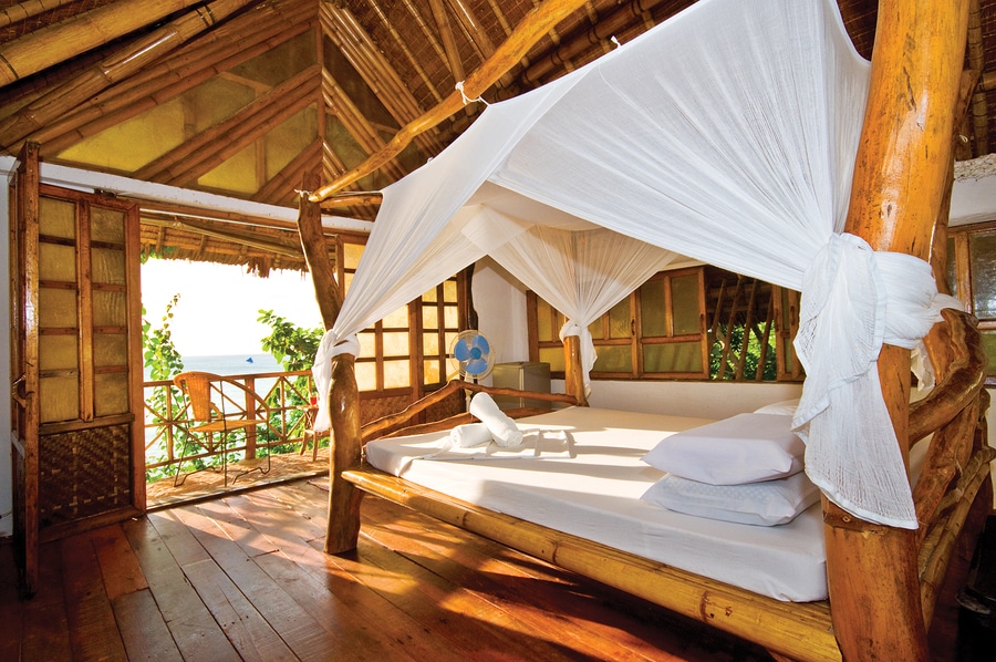 eco lodge bedroom with bamboo furniture and natural organic linens