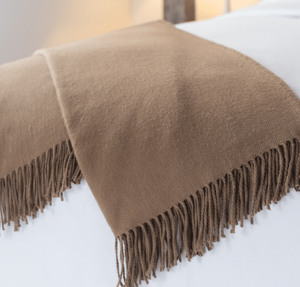 Sobel Westex alpaca blanket in brown on a white hotel bedspread