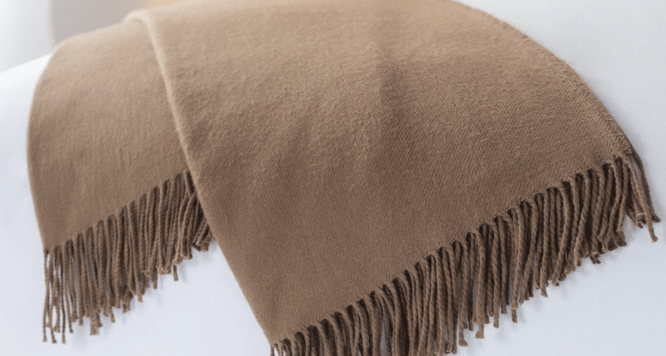 Sobel Westex alpaca blanket in brown on a white hotel bedspread