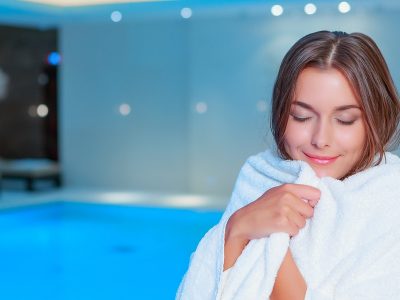beautiful woman swimmer at the gym, hotel or spa wrapped in a luxury hotel towel