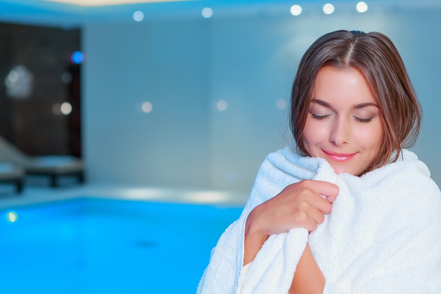 beautiful woman swimmer at the gym, hotel or spa wrapped in a luxury hotel towel