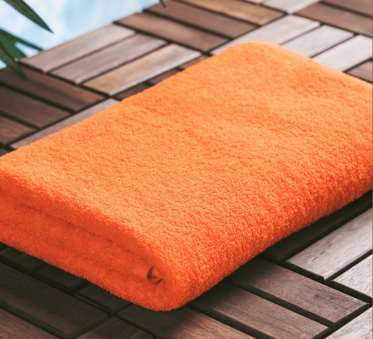 orange solid color Sobel Westex pool towel on wooden bench by swimming pool