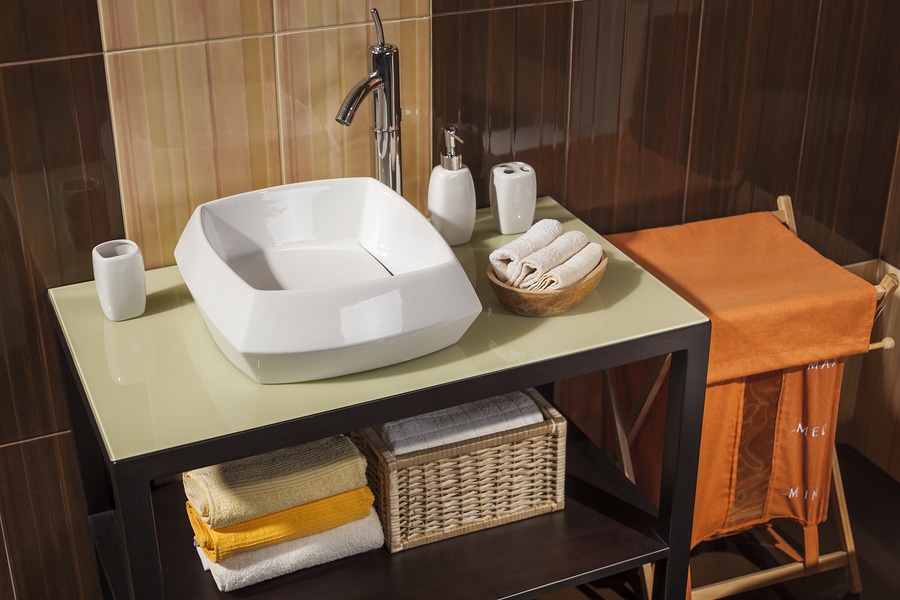 clean and modern guest bathroom with sink towels and laundry basket