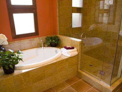 Luxurious bathroom with a modern designer tub and shower, towels and plants ready for guests