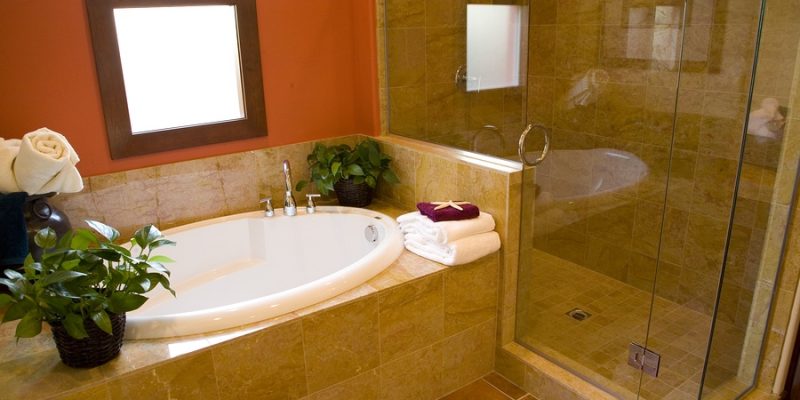 Luxurious bathroom with a modern designer tub and shower, towels and plants ready for guests