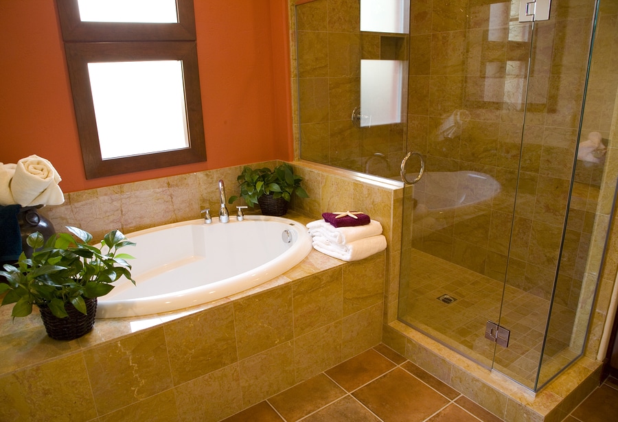 Luxurious bathroom with a modern designer tub and shower, towels and plants ready for guests
