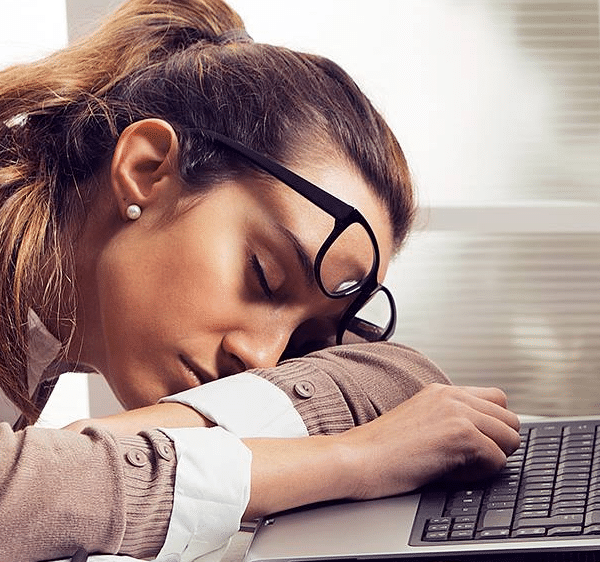 Woman sleeping at computer needs a good night's sleep on a good pillow