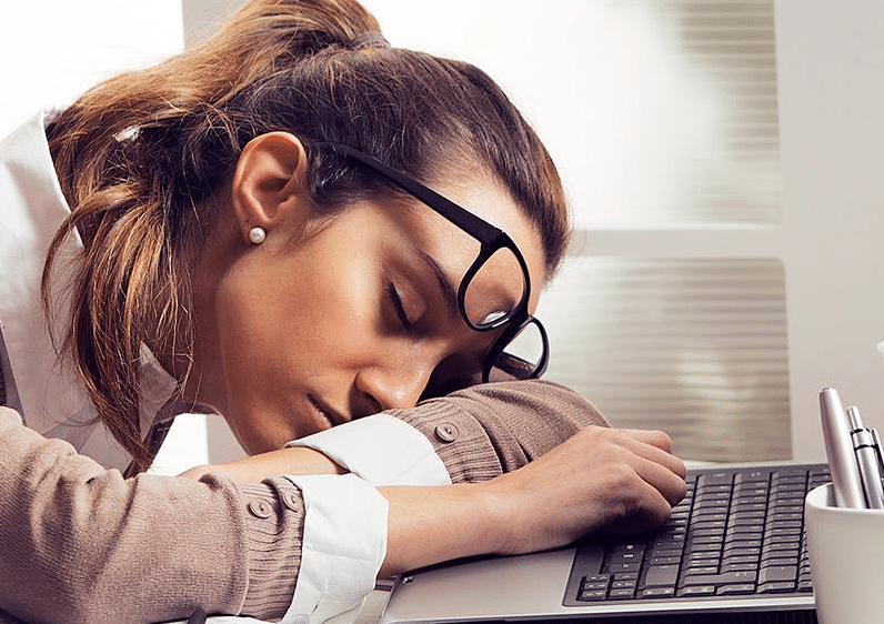 Woman sleeping at computer needs a good night's sleep on a good pillow