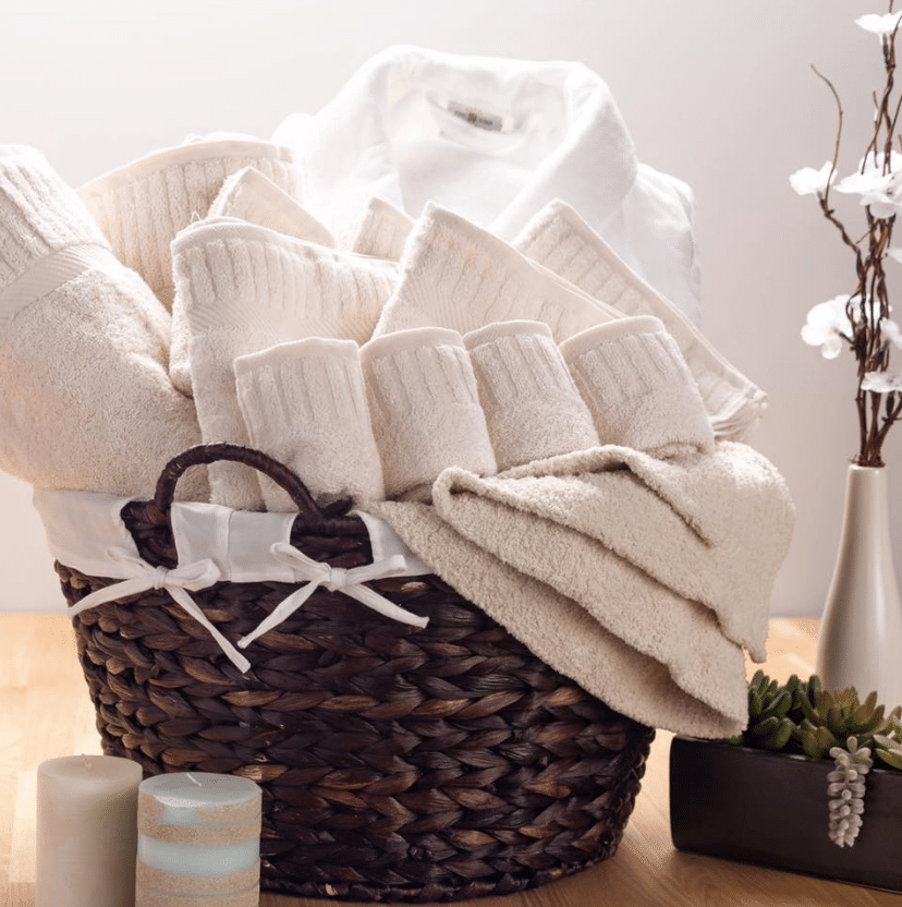 Sobel Westex hotel towels and bathrobe in decorative basket for guest bathroom