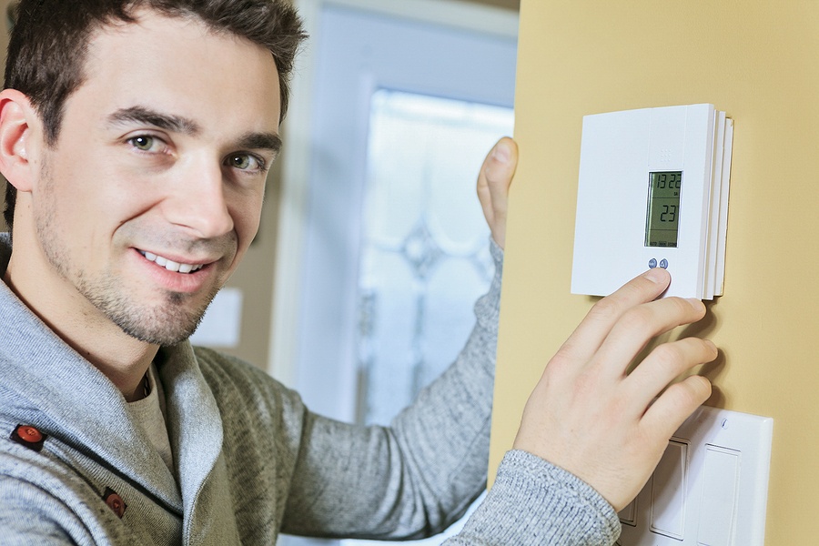 A man set the thermostat in winter at house.