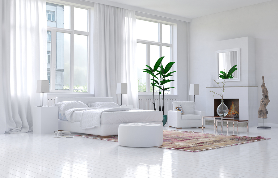 Contemporary spacious white bedroom interior with white hotel quality bed linens