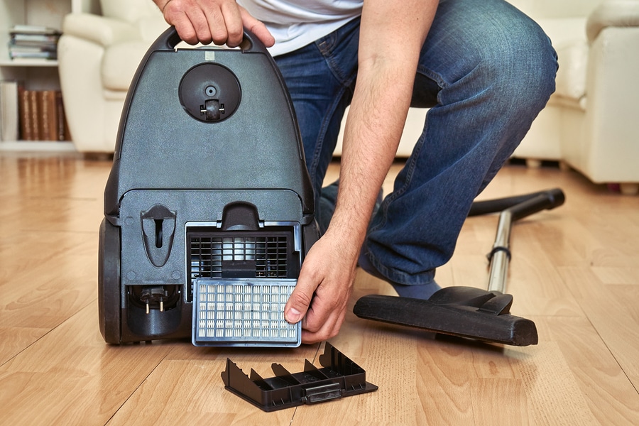 Man replacing a hepa filter in vacuum cleaner cleaning for dust mites and allergens