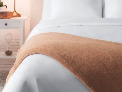 Sobel Westex Sahara Nights white bed sheets on a beautiful hotel bed with a soft brown alpaca throw