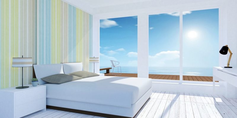 White and pastel modern bedroom interior with sea view in summer