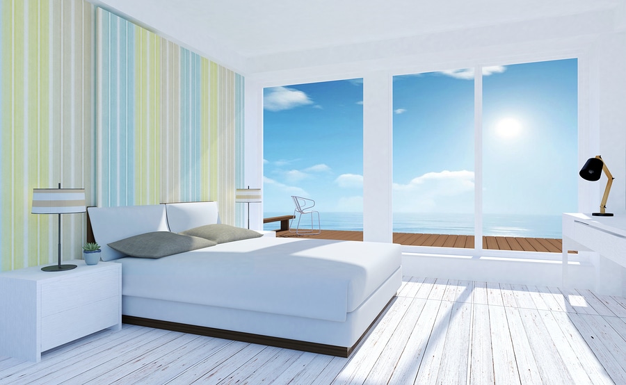 White and pastel modern bedroom interior with sea view in summer