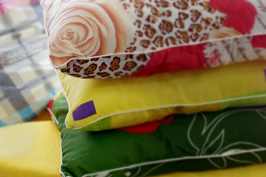 Three colorful pillows and pillowcases stacked in a pile