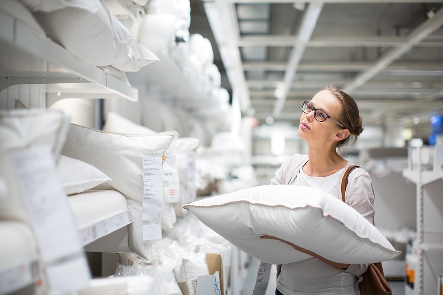 Young woman shopping for new pillow choosing the right pillow filling