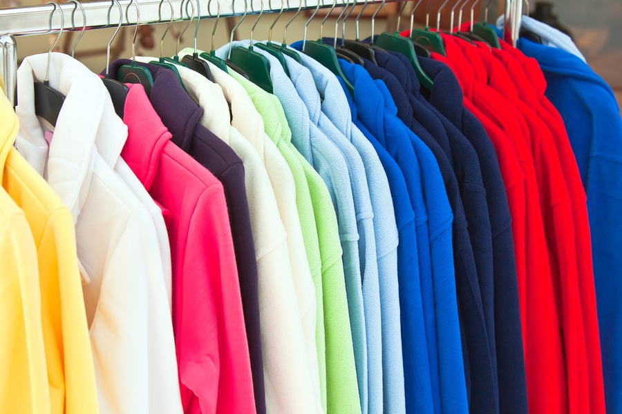 colorful fleece jackets hanging in row at store