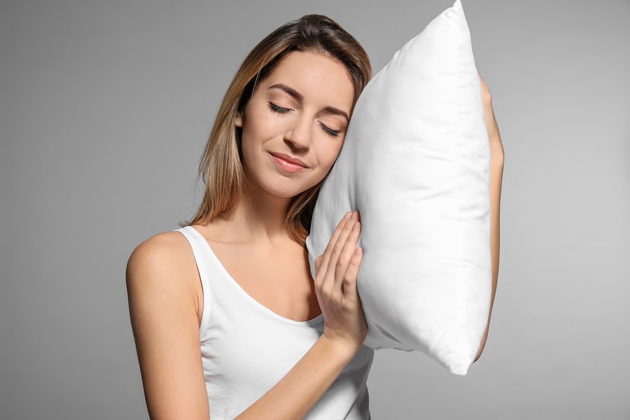 Young woman happyhugging her new soft bed pillow