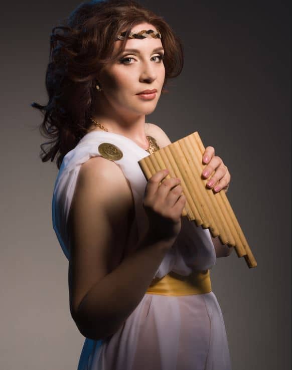 woman dressed in white bed sheet costume with gold belt and clasp and a lute, as a roman goddess for Halloween