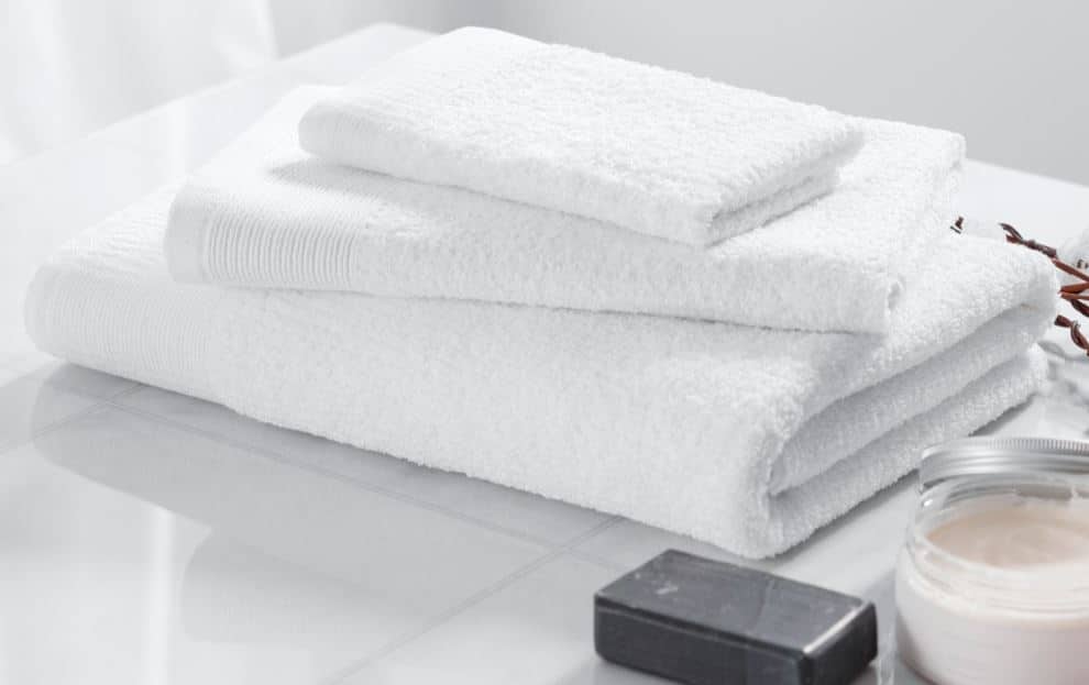Stack of white Sobellina hotel towels and luxury bar soap