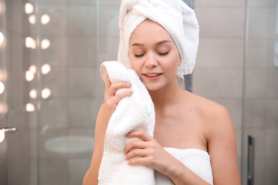 Beautiful woman with clean luxury bath towels in bathroom