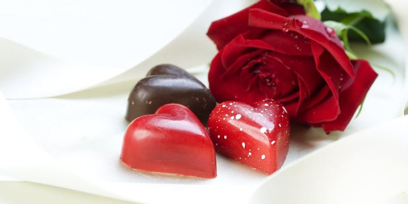 Valentine's Day card and chocolate hearts and red rose