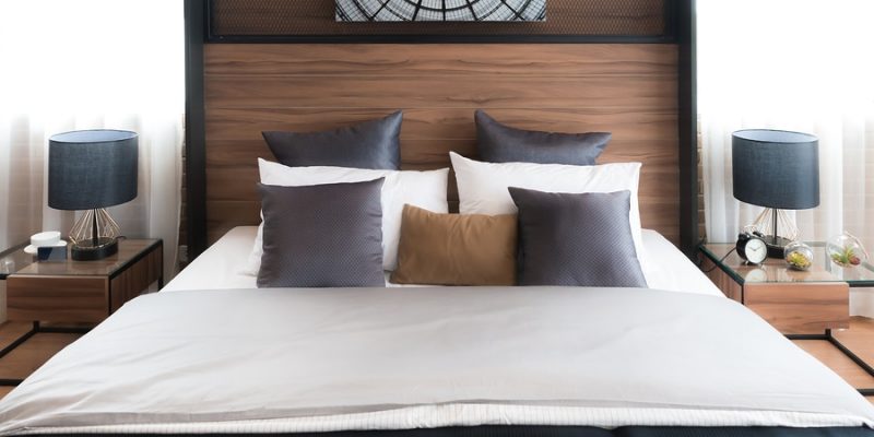 hotel bed with neat crisp percale sheets and brown and gold matching pillows