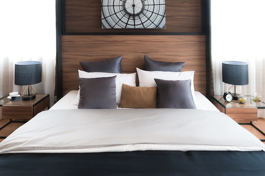 hotel bed with neat crisp percale sheets and brown and gold matching pillows