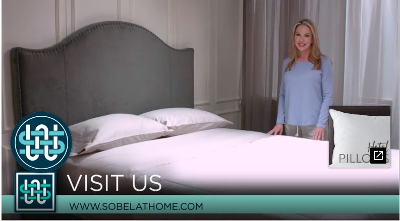 Hostess showing bed made like a luxury hotel using rose color Sobel luxury hotel sheets and pillows