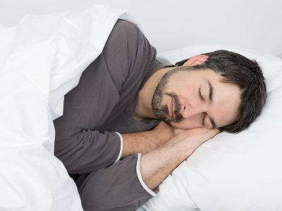 man with beard sleeping on his side on a comfortable pillow for a side sleeper