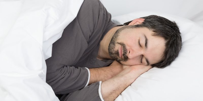 man with beard sleeping on his side on a comfortable pillow for a side sleeper