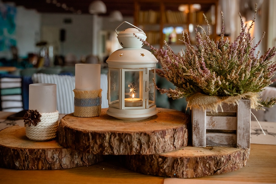 fall season home decoration made of cozy candles and dried floral arrangement on wood blocks with home in background