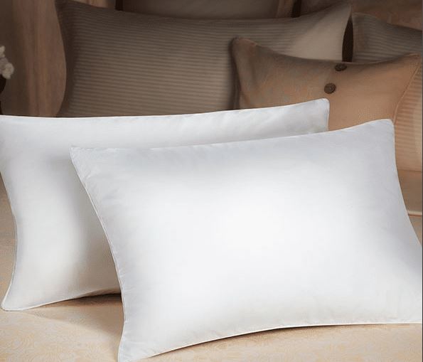 Two white Dolce vita eco pillows by Sobel on hotel bed
