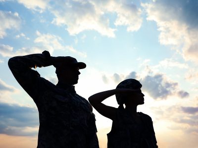 Soldiers in uniform saluting against the sky at armed forces celebration