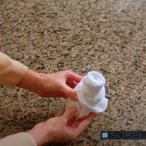 Woman demonstrating how to roll a washcloth in the form of a rosebud