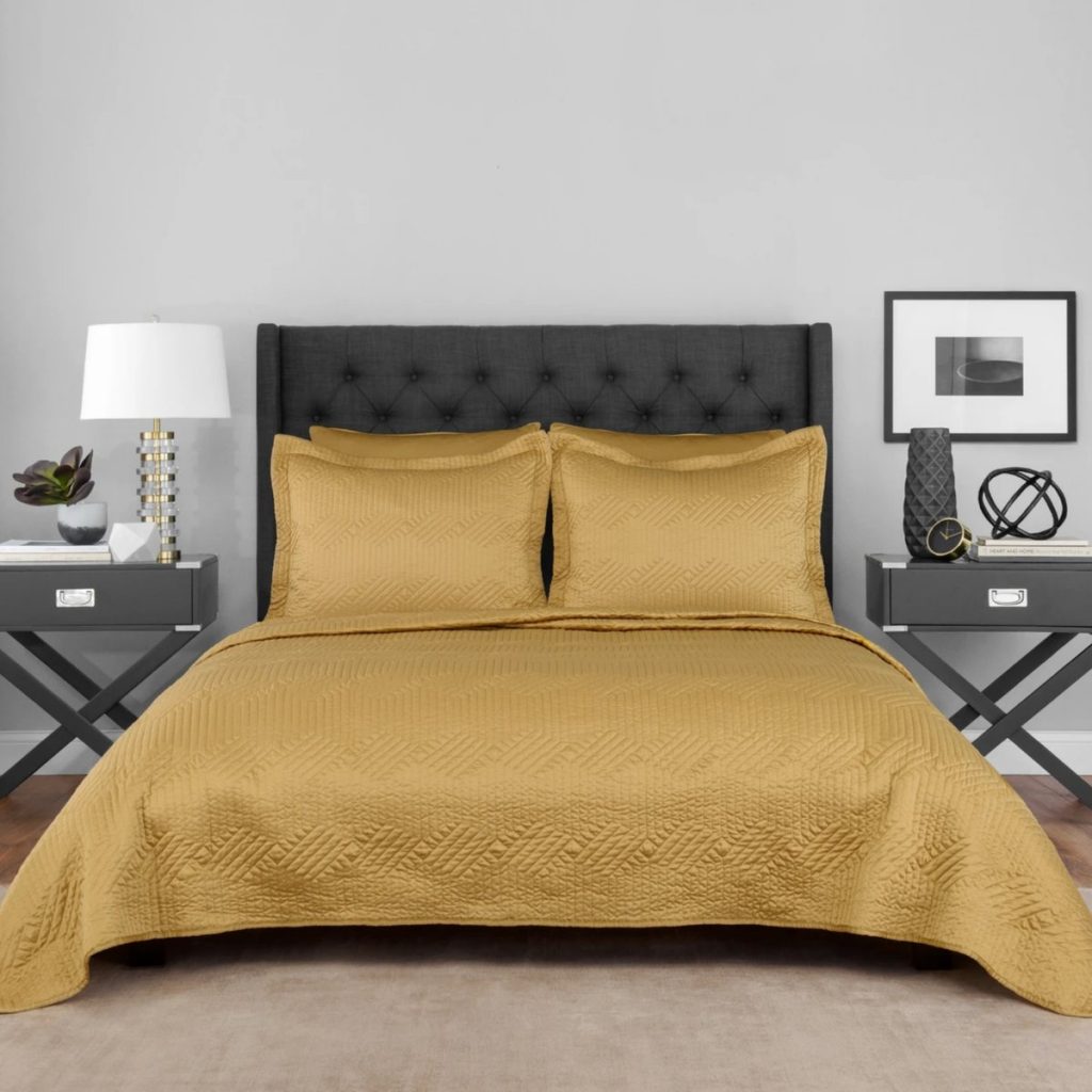 elegant gold collaboration series Lionel Richie gold coverlet set by Sobel at Home dsiplayed on hotel bed