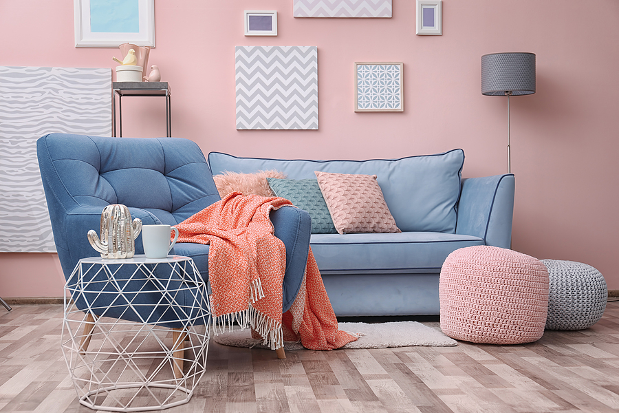 Modern living room interior with blue armchair and textured pillows and footstools