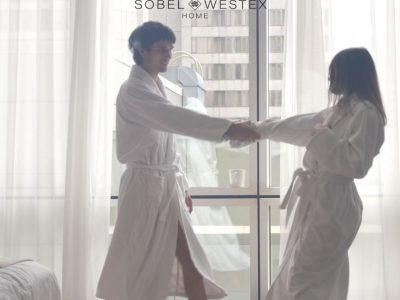 A couple dancing in a hotel room wearing luxury hotel spa bathrobes