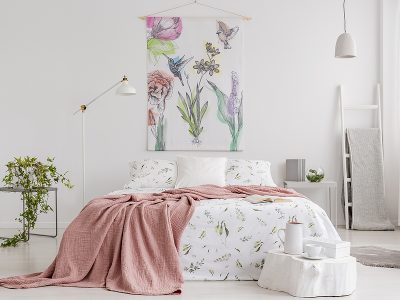 Spring colors pastel bedroom interior with a big bed in the middle and a painted fabric art on the wall.