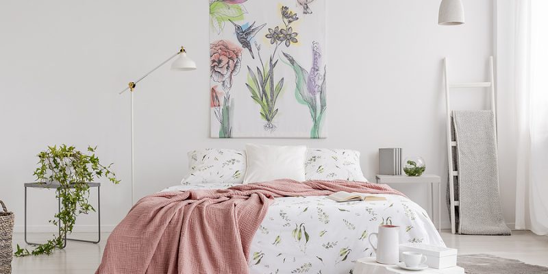 Spring colors pastel bedroom interior with a big bed in the middle and a painted fabric art on the wall.