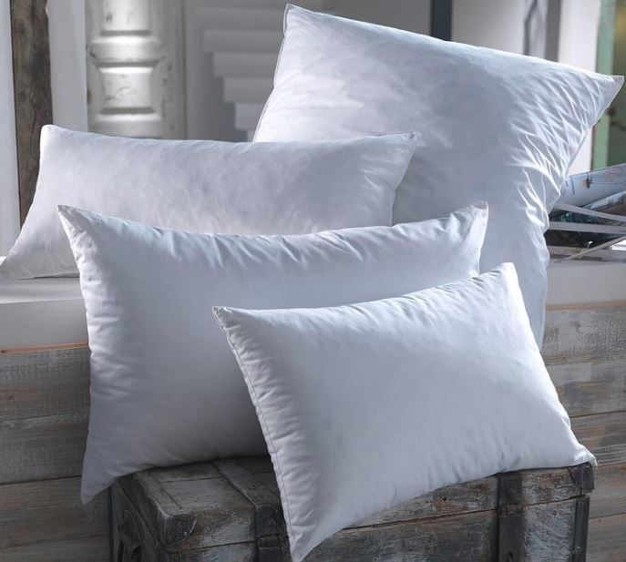 Four luxury hote; pillows of different sizes posed in a stylish pile