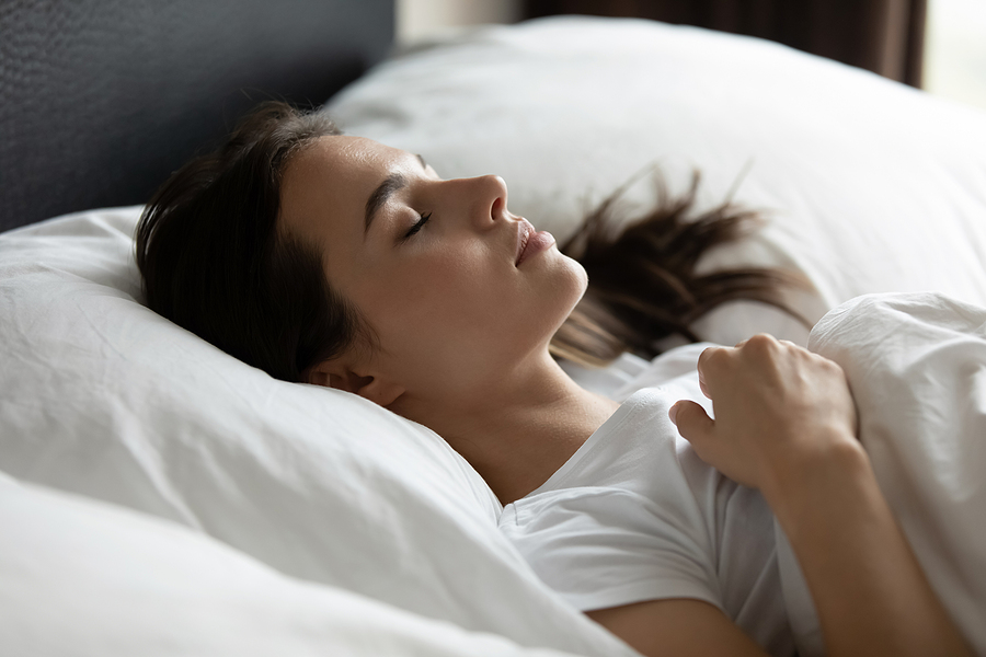 Calm young woman resting comfortably in a back sleeping position