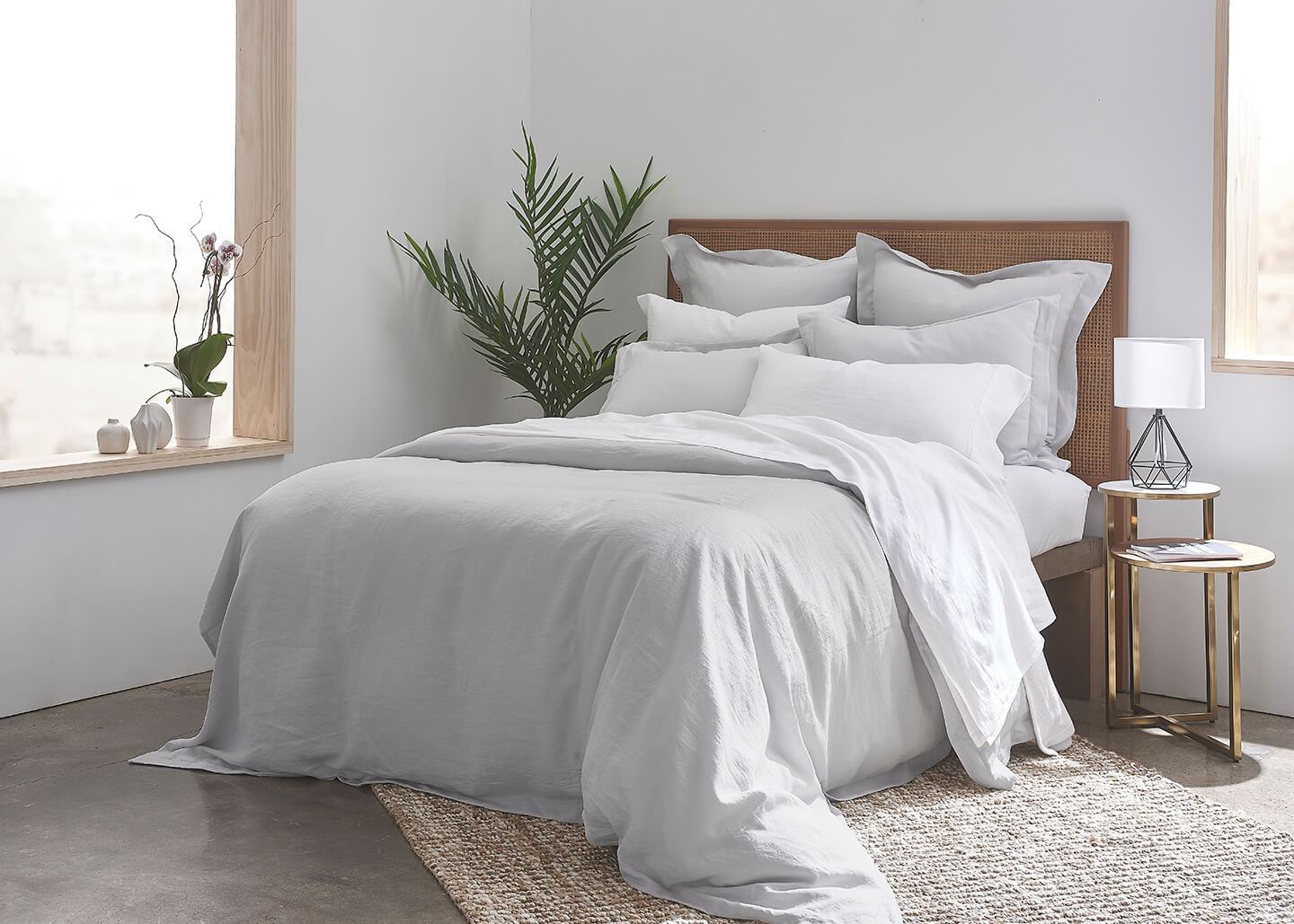 gray linen duvet cover on a luxury double bed with plush pillows in a minimalist bedroom